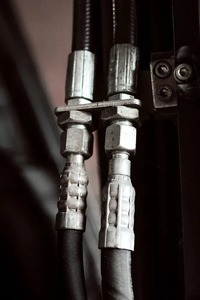 Närbild på hydraulslangar med kopplingar